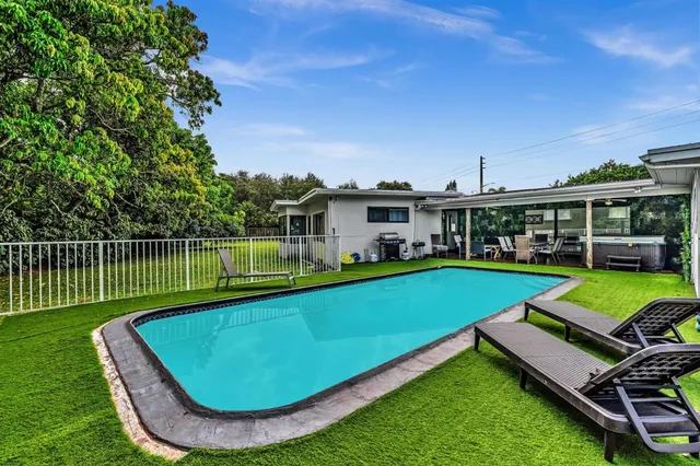 a view of a house with a backyard patio and swimming pool