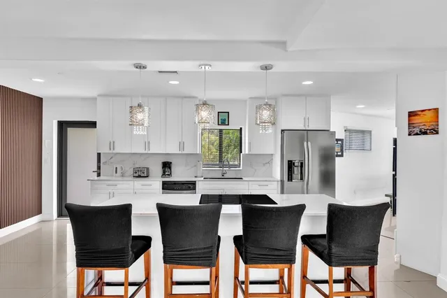 a kitchen with a dining table chairs refrigerator and cabinets