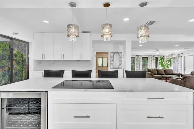 a large white kitchen with a chandelier