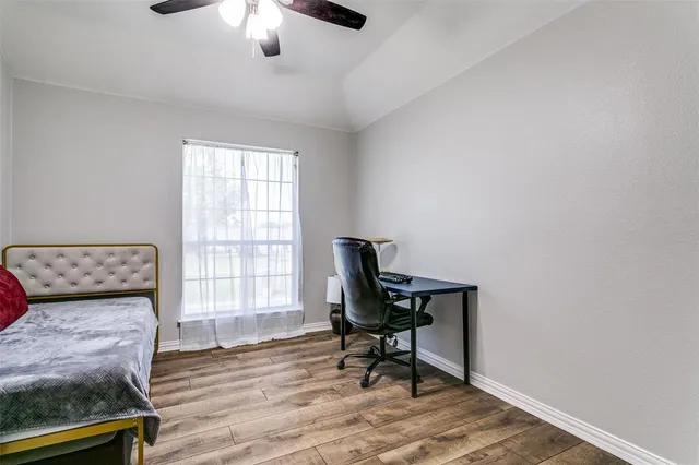 a workspace with wooden floor and a window