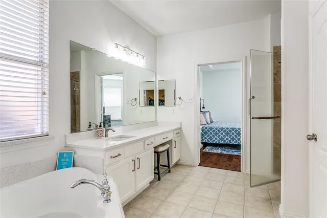 a bathroom with a tub sink and mirror