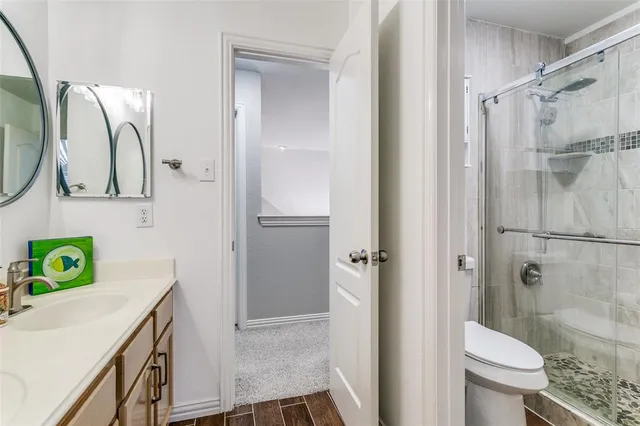 a bathroom with a sink a toilet and shower