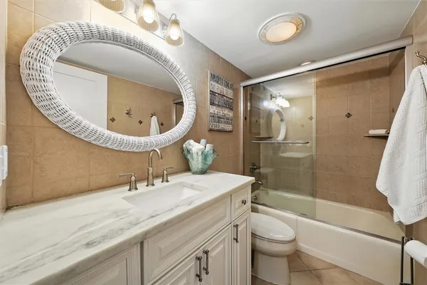 a bathroom with a granite countertop sink mirror toilet and bathtub