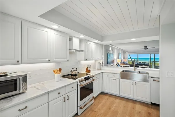a kitchen with a sink a stove and cabinets