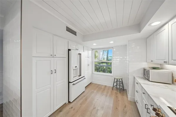 a kitchen with stainless steel appliances granite countertop a refrigerator a stove and a wooden floors