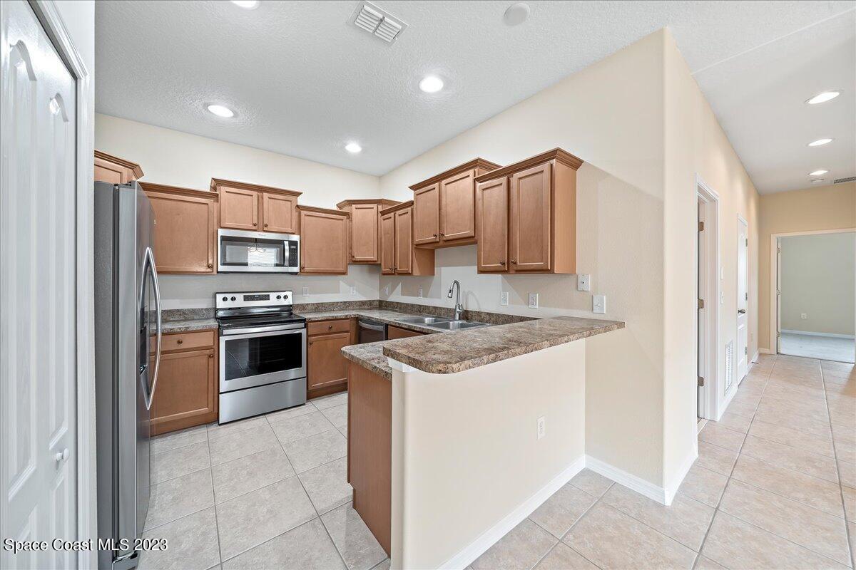 3680 Funston Circle Melbourne, FL 32940 - Photo 11 of 48 a kitchen with stainless steel appliances granite countertop a stove top oven a sink and a refrigerator
