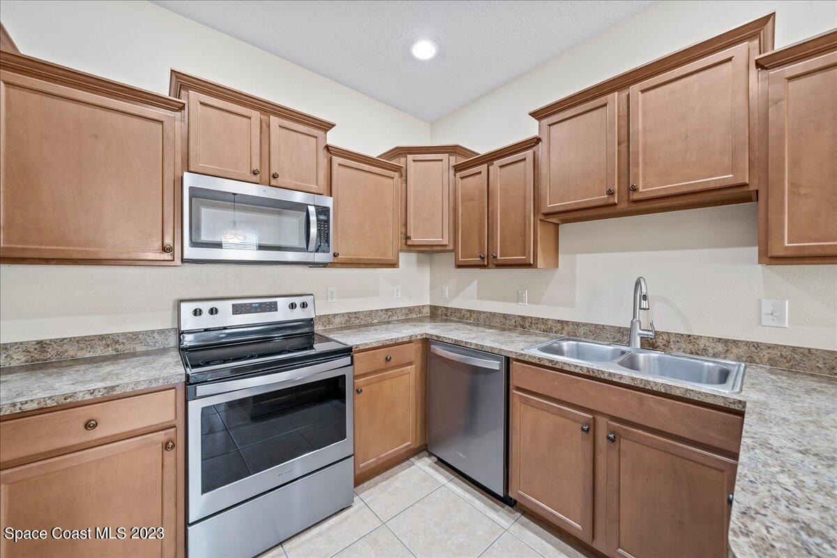 3680 Funston Circle Melbourne, FL 32940 - Photo 12 of 48 a kitchen with granite countertop a sink stove and microwave