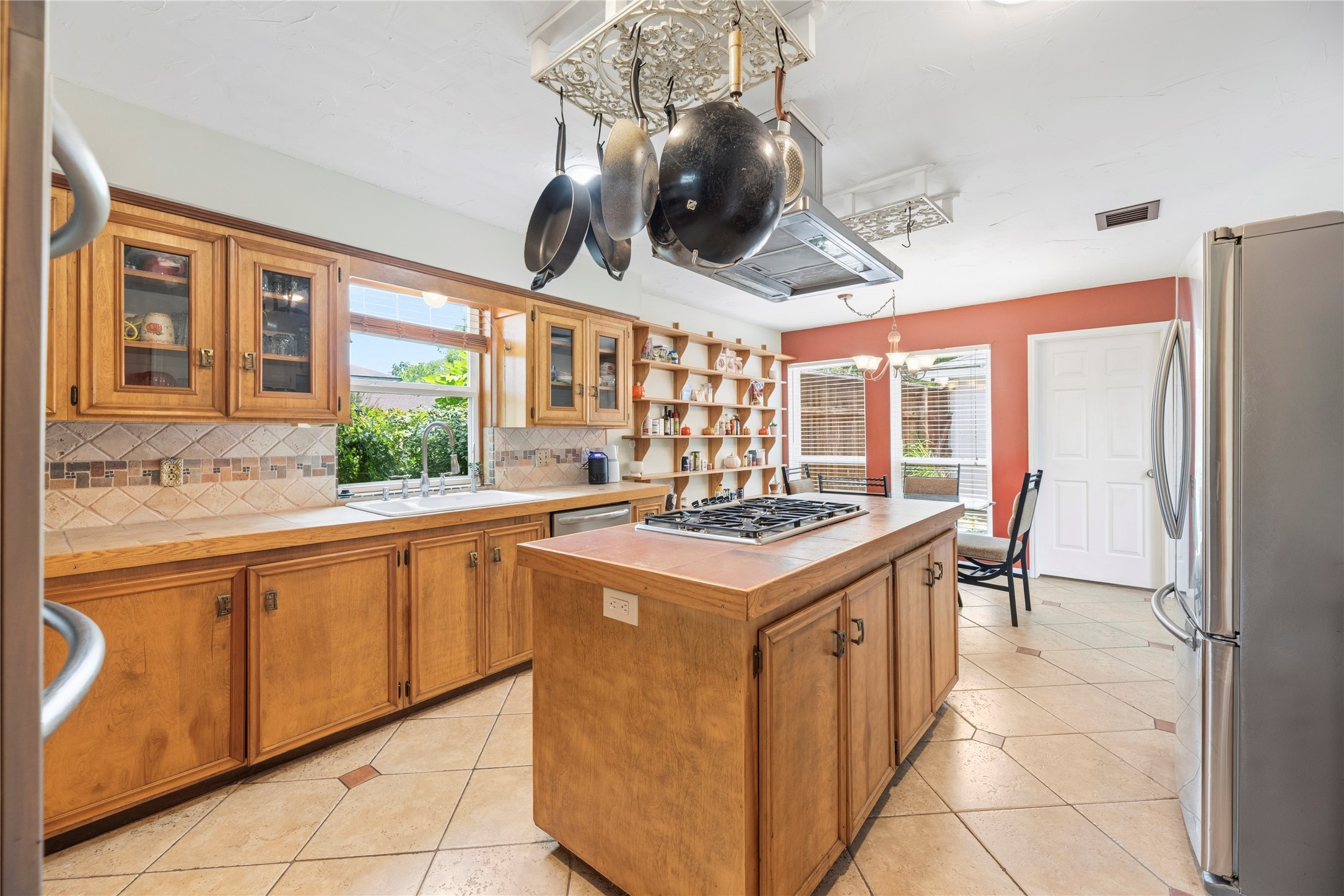 14203 Wickersham Lane Houston, TX 77077 - Photo 4 of 25 Panoramic view of the kitchen work triangle highlighting the deep double sink below a picture window, detailed tile accents, and an expansive layout that flows effortlessly into the casual dining space.
