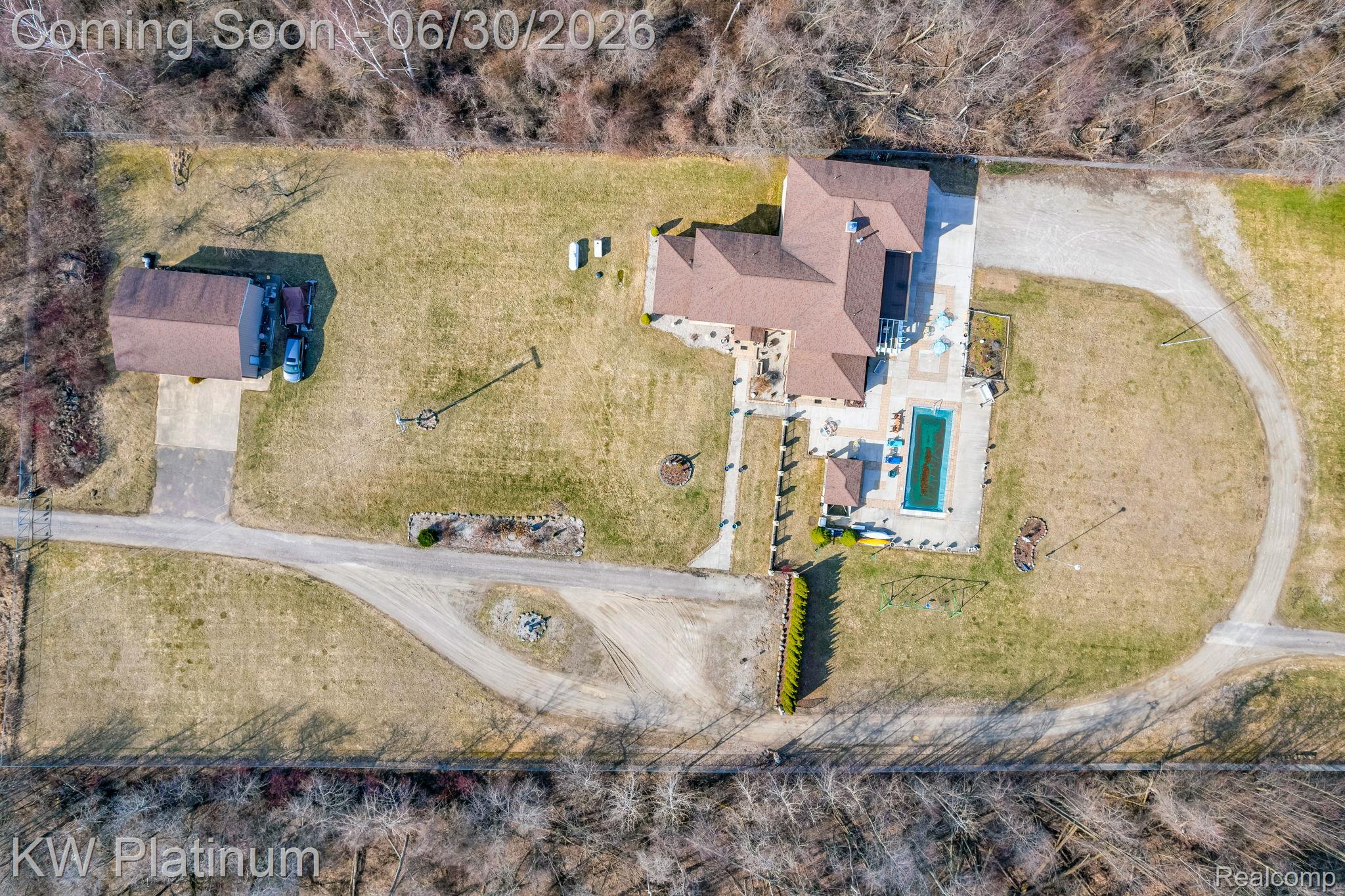 2235 South Lake Shore Road Harbor Beach, MI 48441 - Photo 56 of 99 Expansive property featuring a main residence with a brown shingle roof, a rectangular swimming pool with surrounding patio, a secondary detached building, and a circular driveway