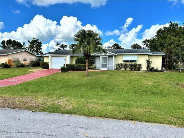 a view of a house with a big yard and potted plants