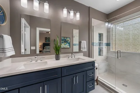 a bathroom with a sink mirror and a shower