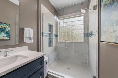 a bathroom with a shower sink and mirror