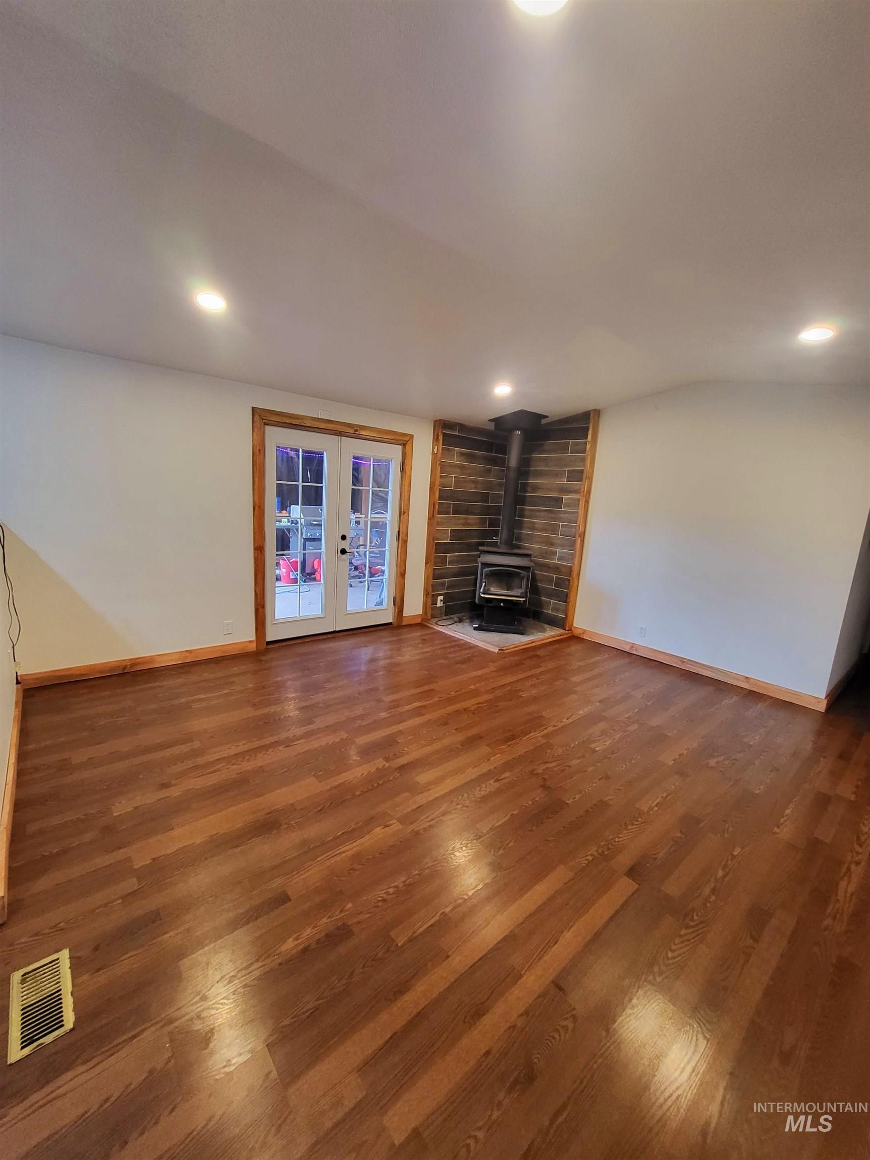 89 Waterfall Loop Orofino, ID 83544 - Photo 2 of 6 Unfurnished living room with a wood stove, dark wood-type flooring, french doors, and recessed lighting