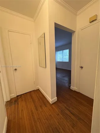 a view of a hallway with wooden floor and closet