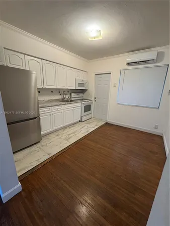 a kitchen with a refrigerator and a stove top oven