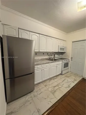 a kitchen with stainless steel appliances a refrigerator sink and microwave