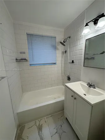 a bathroom with a bathtub sink mirror and toilet