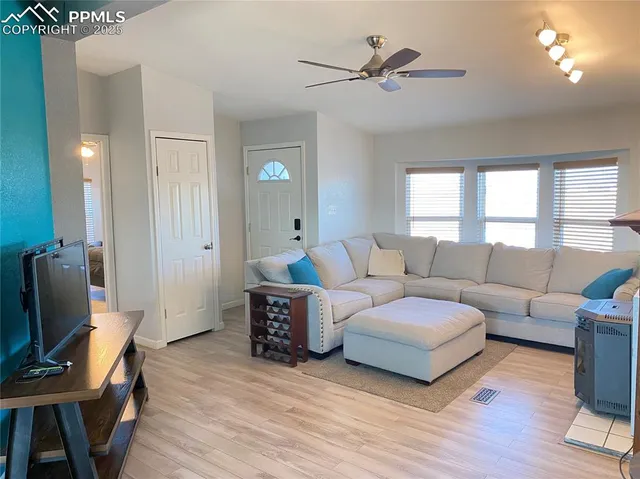 a living room with furniture a fireplace and a large window