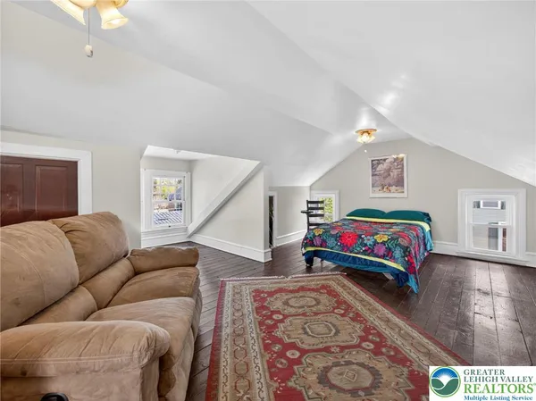 a view of a dining room with furniture a rug and wooden floor