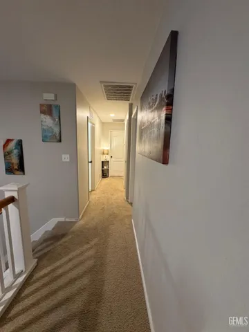 a view of a hallway with wooden floor and a bathroom