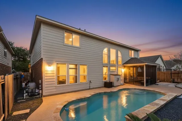 a view of a house with swimming pool and sitting area
