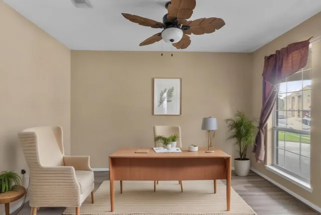 a view of a workspace with furniture and a window