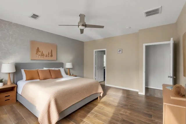 a bedroom with a large bed and a ceiling fan