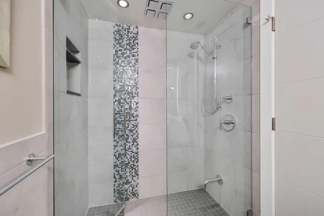 a bathroom with a shower and a glass door