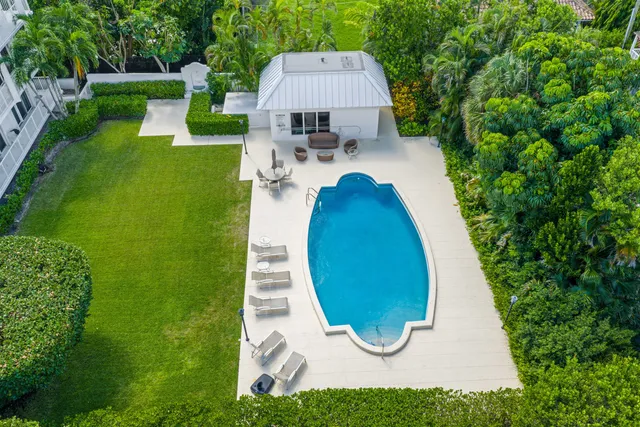 a view of a swimming pool with sitting area and garden