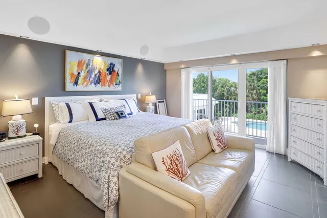 a bedroom with furniture and a large window