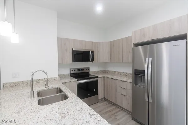 a kitchen with stainless steel appliances a sink stove and refrigerator