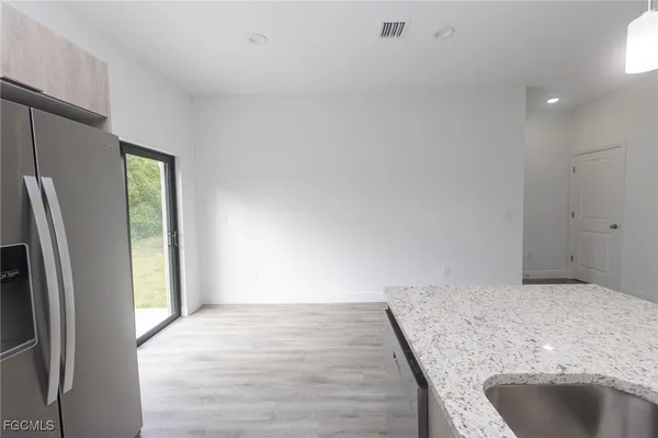 a view of a kitchen with a sink and refrigerator