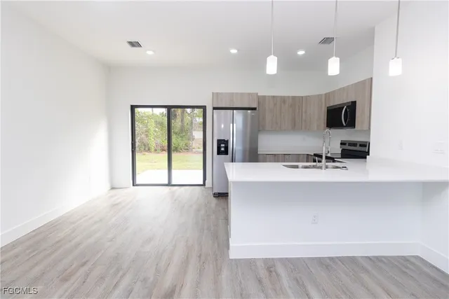 a large white kitchen with wooden floors and a fireplace