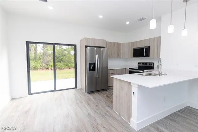 a view of a kitchen with a sink and a refrigerator