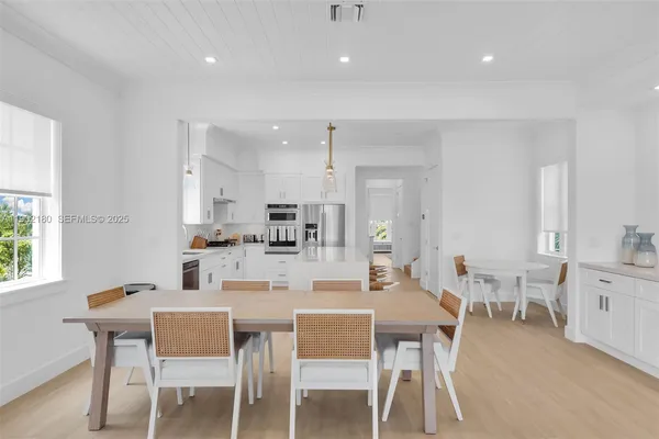 a kitchen with kitchen island a stove a table and chairs in it