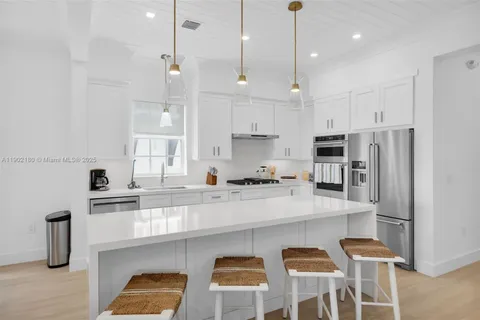 a kitchen with stainless steel appliances white cabinets and wooden floors