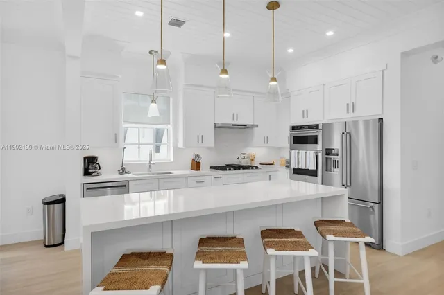 a kitchen with stainless steel appliances white cabinets and wooden floors