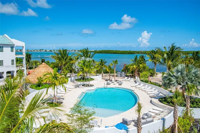 a view of swimming pool with outdoor seating and house in the background