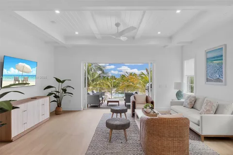 a living room with furniture a chandelier and a large window