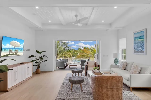 a living room with furniture a chandelier and a large window