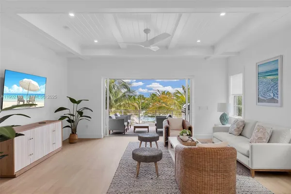 a living room with furniture a chandelier and a large window