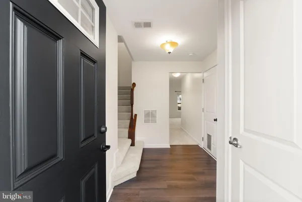 a view of an empty room with wooden floor and a fireplace