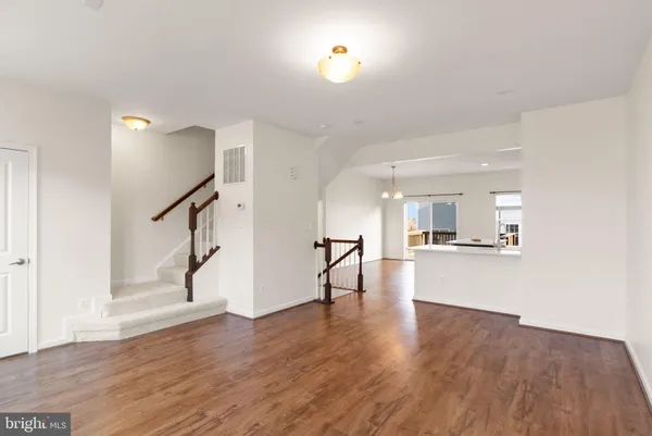 a kitchen with a sink a stove cabinets and wooden floor