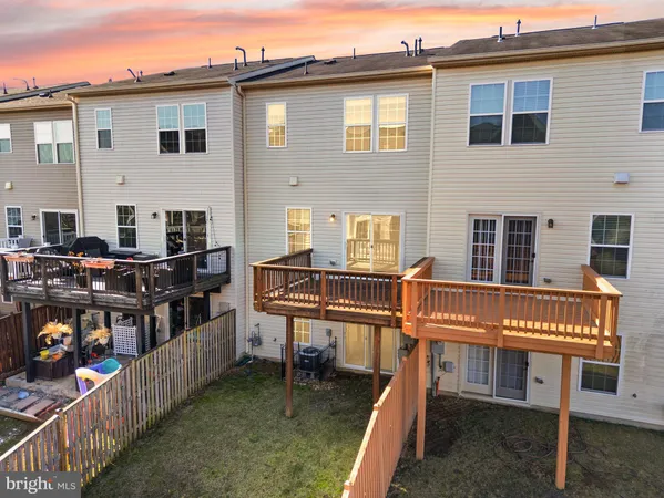 a view of a white house with a small yard and large tree
