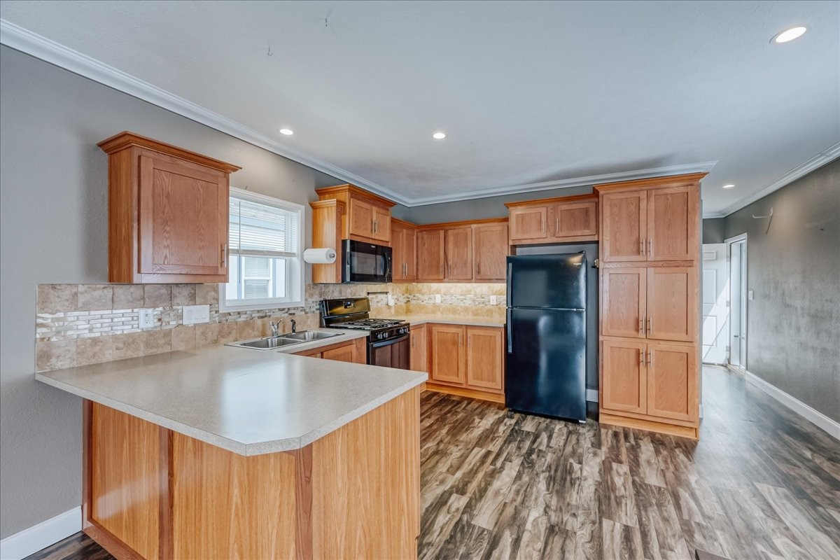 a kitchen with stainless steel appliances granite countertop a sink refrigerator and cabinets