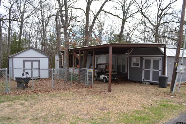 a view of house with backyard and furniture