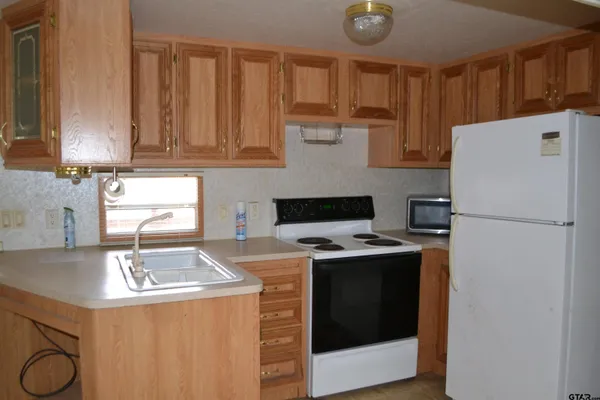 a kitchen with a stove a refrigerator and a sink
