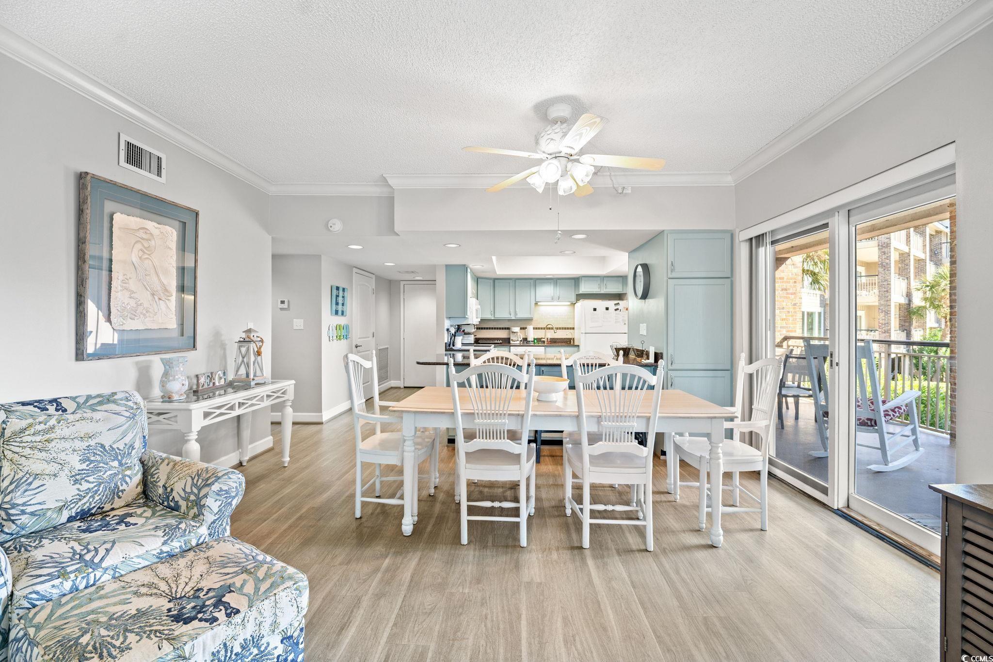 320 Myrtle Avenue Pawleys Island, SC 29585 - Photo 17 of 38 Dining room with ornamental molding, light wood-style flooring, a textured ceiling, and a ceiling fan
