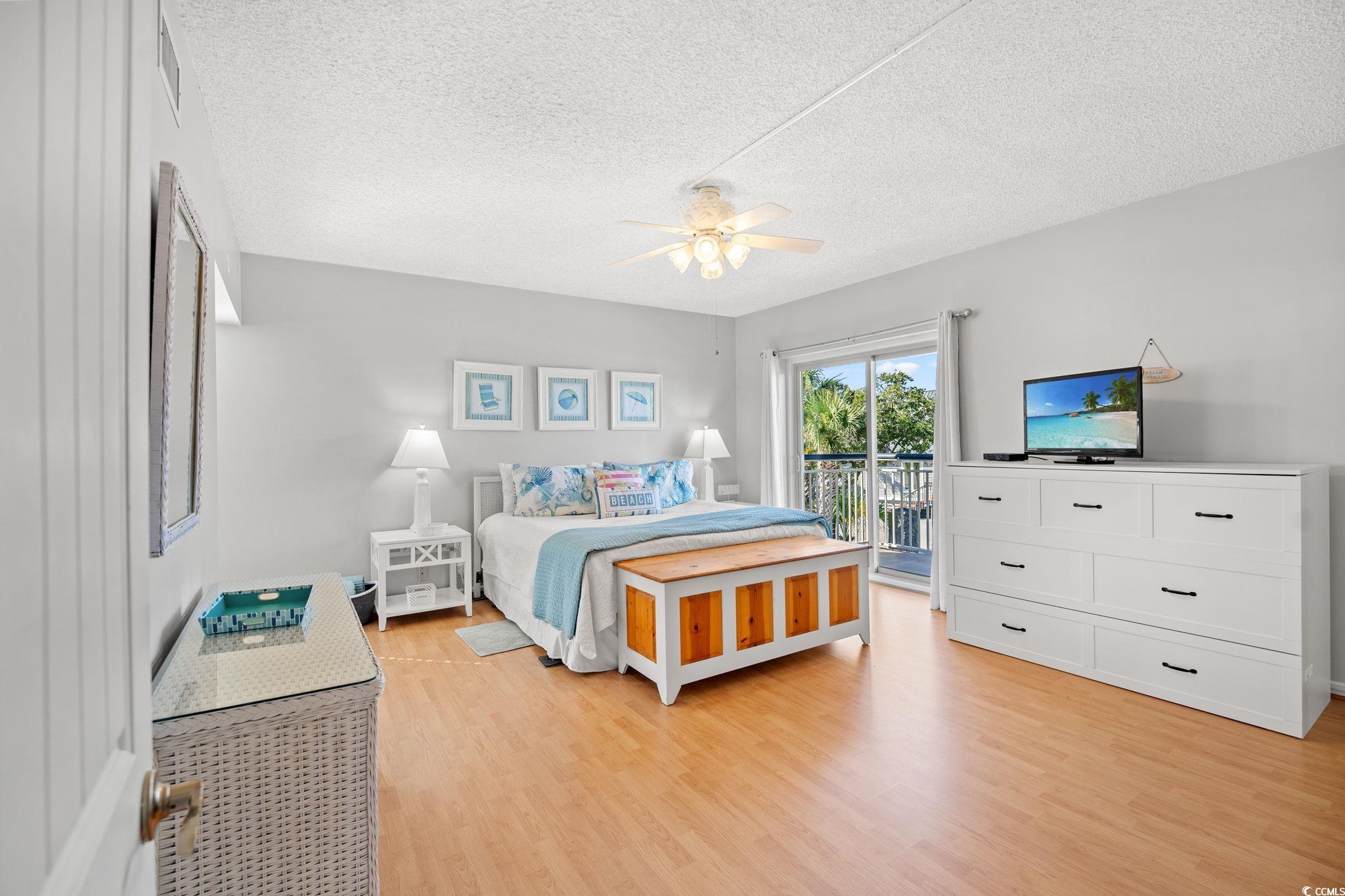 320 Myrtle Avenue Pawleys Island, SC 29585 - Photo 22 of 38 Bedroom featuring light wood finished floors, a textured ceiling, access to exterior, and ceiling fan