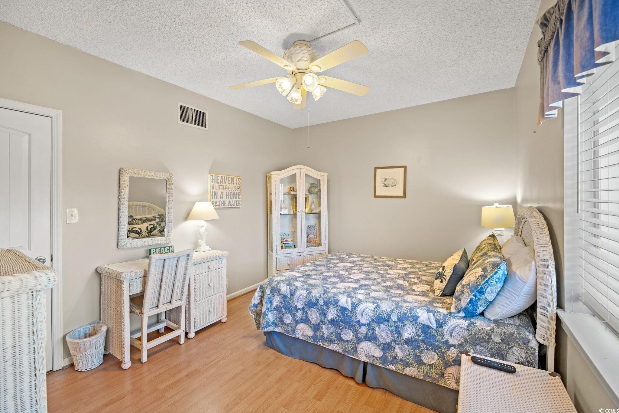 320 Myrtle Avenue Pawleys Island, SC 29585 - Photo 32 of 38 Bedroom featuring light wood-style floors, a textured ceiling, and ceiling fan